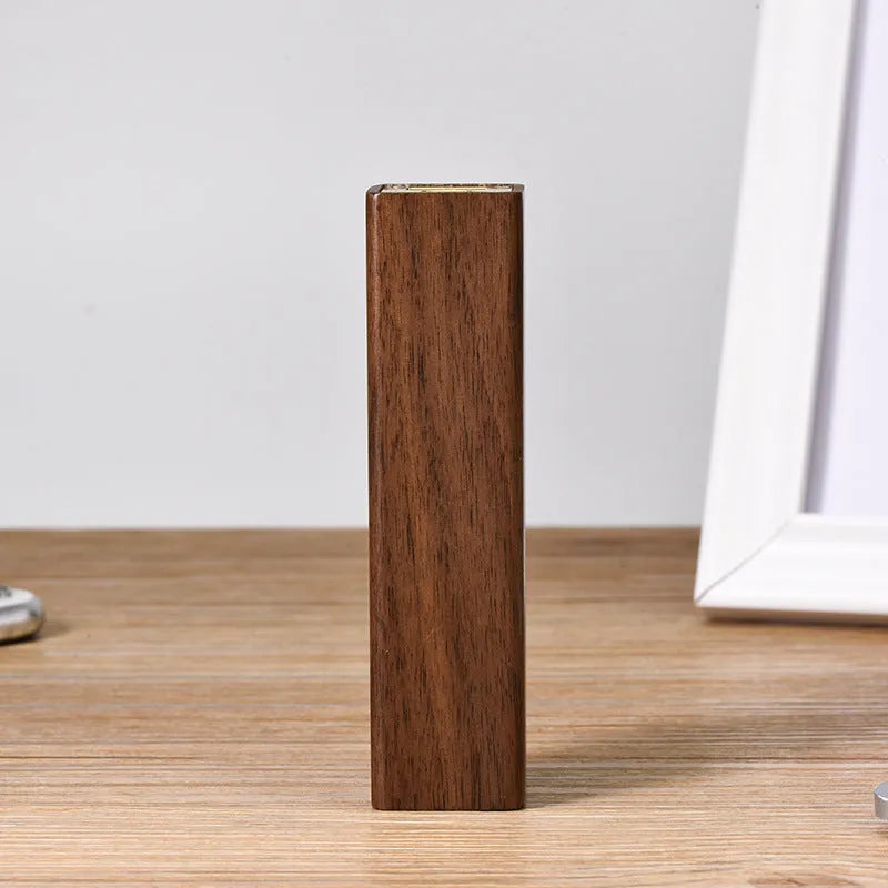 Black walnut wood portable power bank showing natural grain, with dimensions 100mm by 25mm.