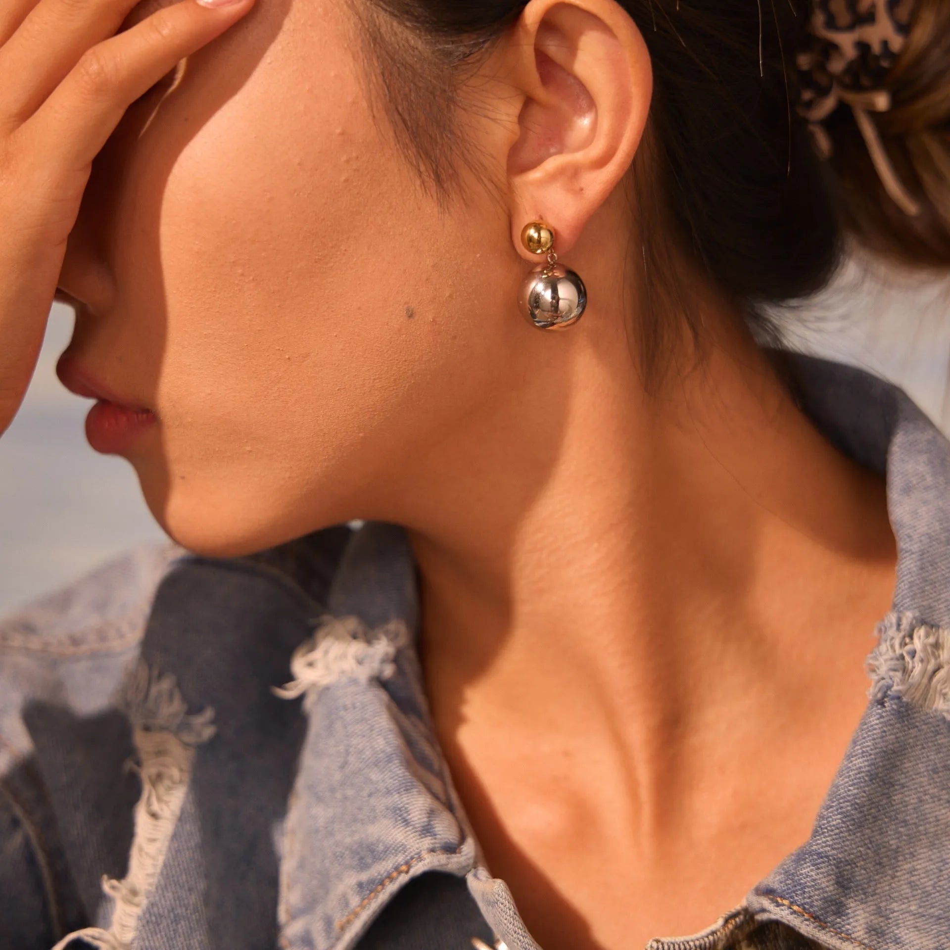 A pair of geometric round bead ear studs with a colour-block finish on stainless steel.