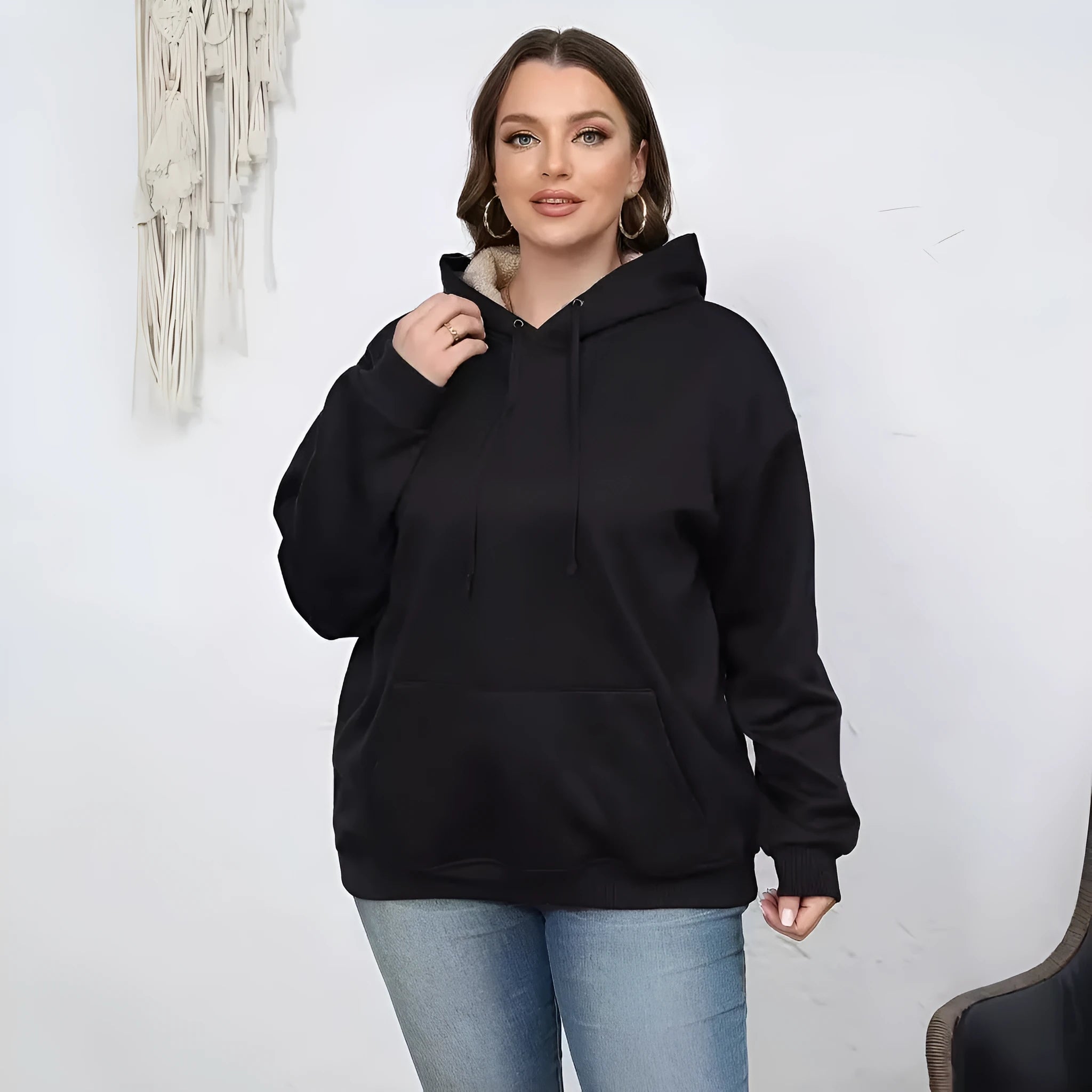 Women's loose-fit black hooded sweater with side pockets and a 3D pattern on the front.