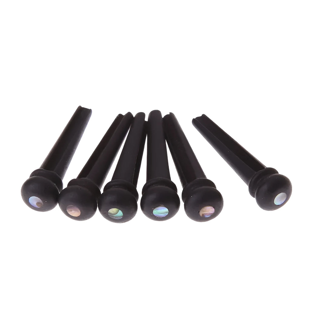 Six matt black ebony folk guitar bridge pins with 5.3mm bayonet diameter on a plain background.