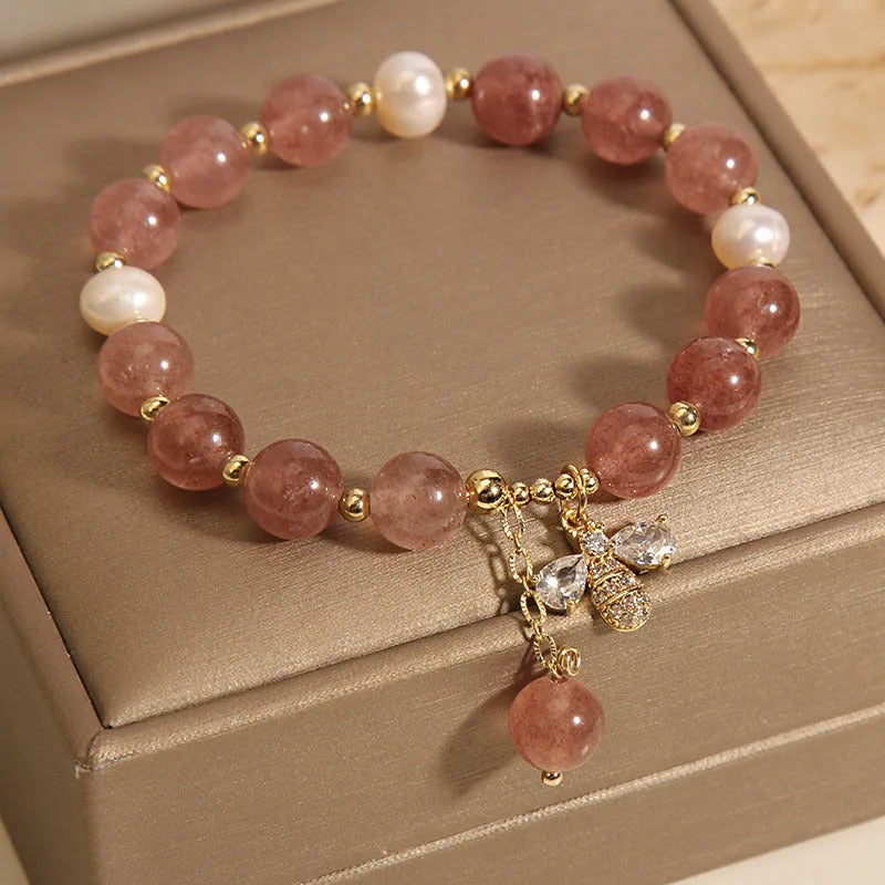 Women's bracelet with strawberry quartz beads, freshwater pearls, and a bee charm.