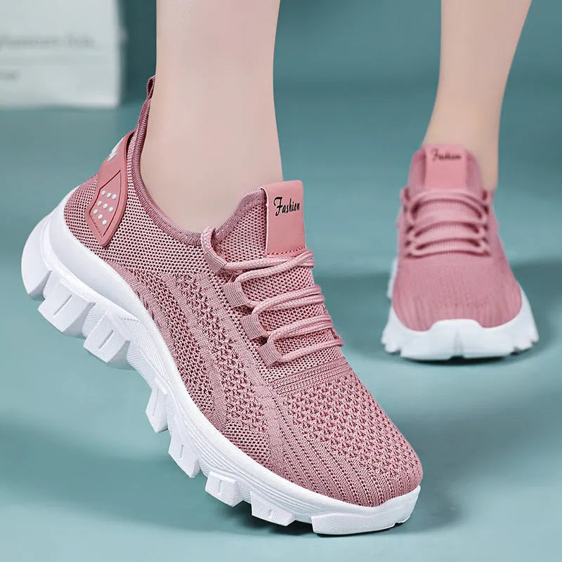 Women's white Flyknit sneakers with thick PVC sole and lace-up design on a neutral background.