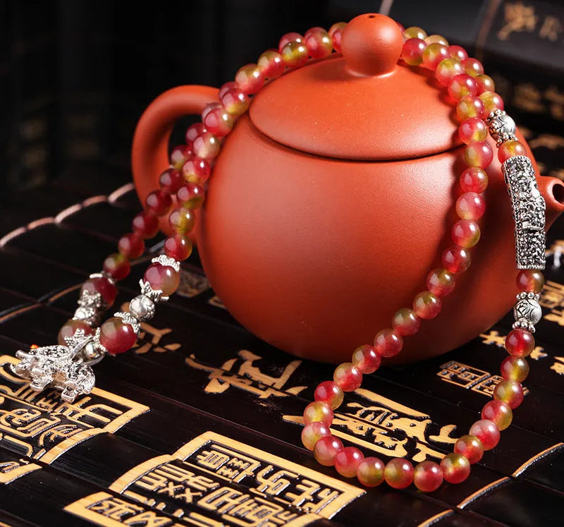 Handmade natural watermelon crystal bracelet with Chinese knots, shown in geometric national style.