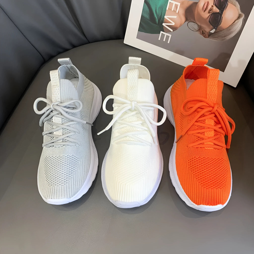 Women's low-top running shoes in Flyknit mesh, shown in creamy white colour with flat rubber sole.