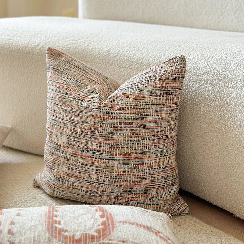 Amber paisley patterned jacquard sofa cushion cover on a sofa, showing textured fabric and plant motif.