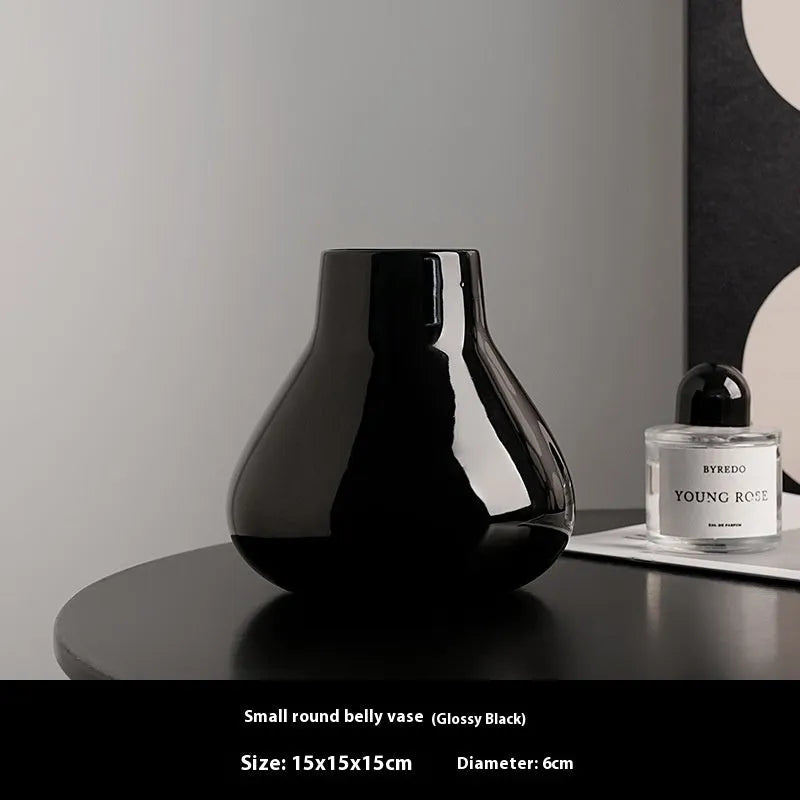 Ceramic round belly vase with coloured glaze finish in black or white, shown with artificial orchid stems