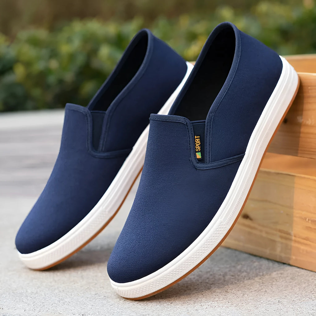 Men's low-top canvas slip-on shoes in black and blue colours showing round toe and composite sole