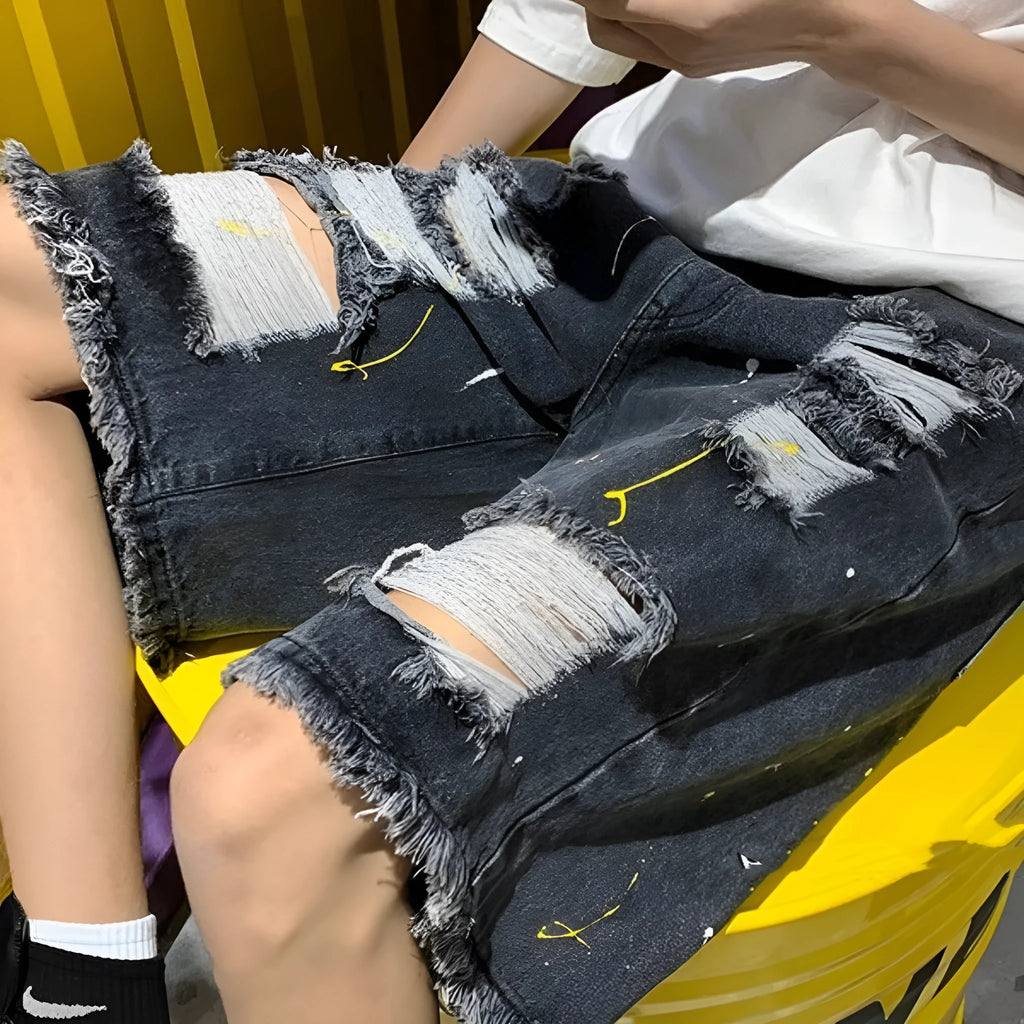 Man wearing loose-fit light blue denim shorts with a water-washed finish and distressed holes.