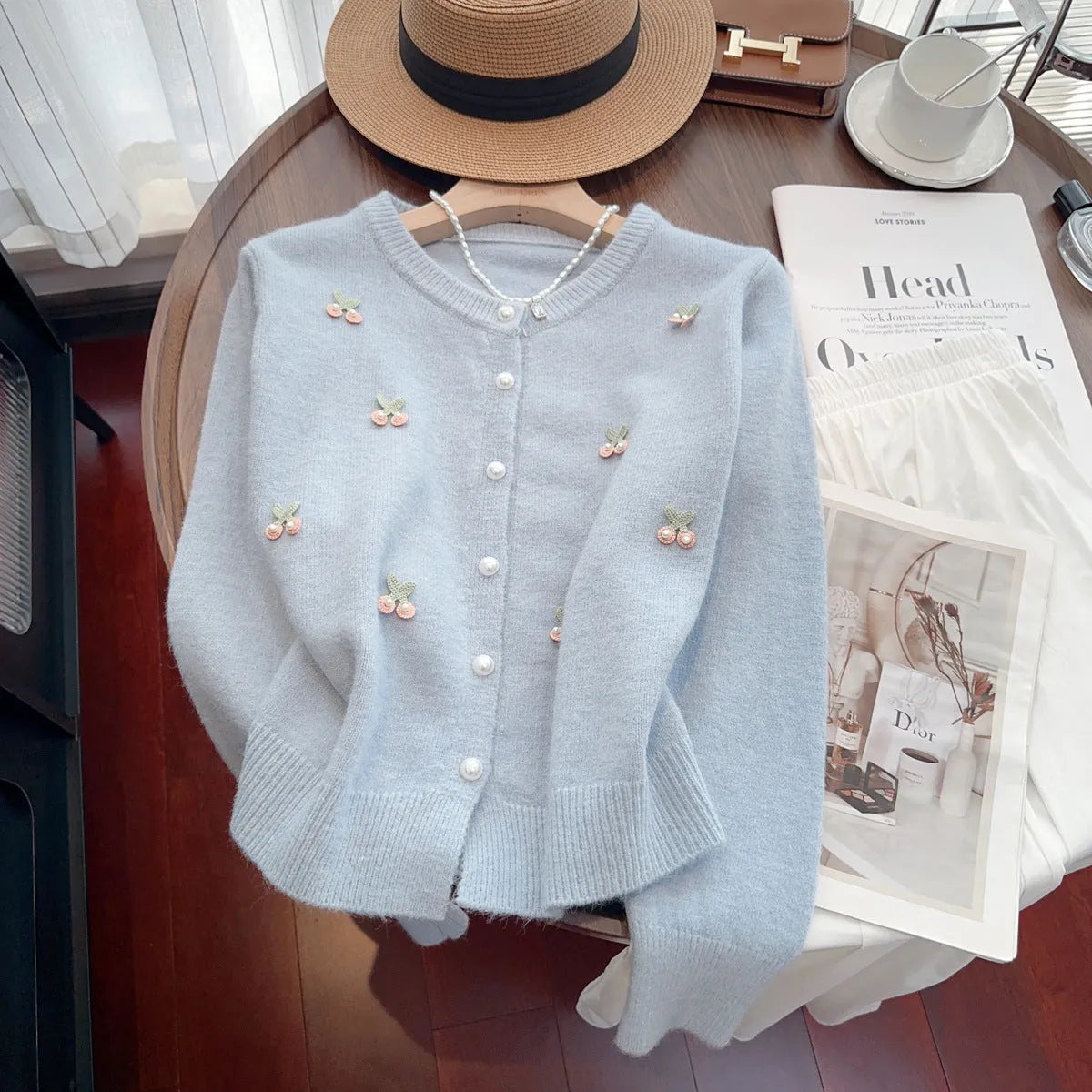 Women's cashmere cardigan coat in blue with beaded detail, shown with round neck and slim fit.