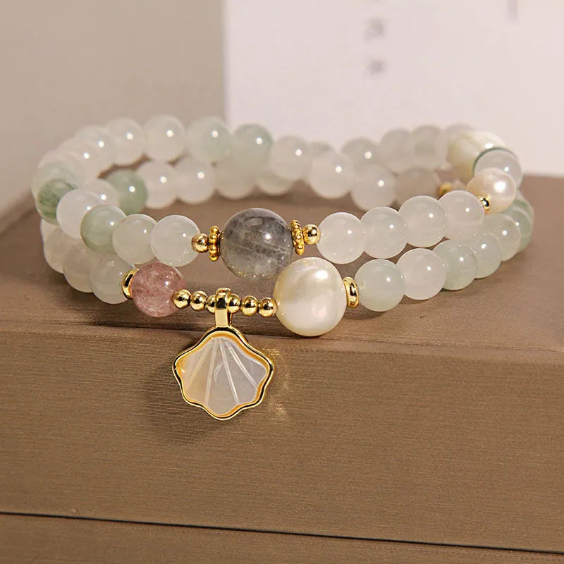 Women's crystal bracelet with a carved jade shell ginkgo leaf pendant on a gold-plated setting.