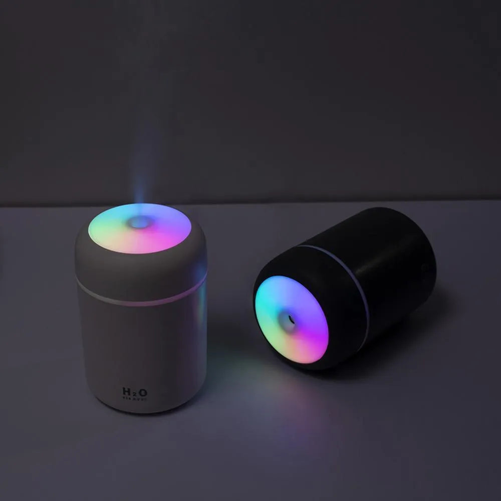 Pink, white or navy blue USB mini humidifier with colourful lights on desk surface