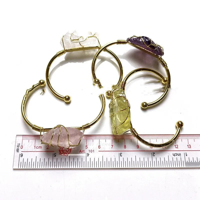 Explosive design natural crystal rough stone bracelet with gold winding on a wrist.