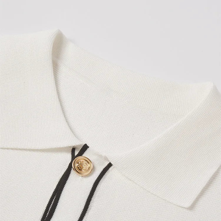 White short sleeve cardigan with dark contrast lapels on a hanger.