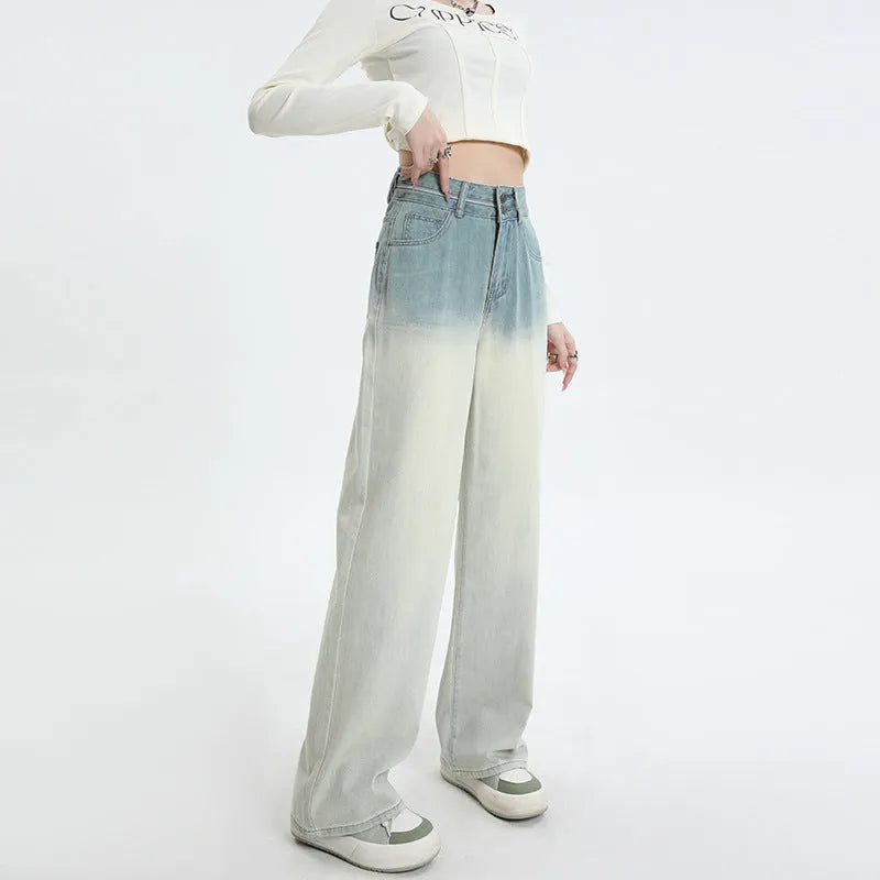 Women's gradient blue denim straight-leg wide-leg trousers laid flat, showing colour fade.