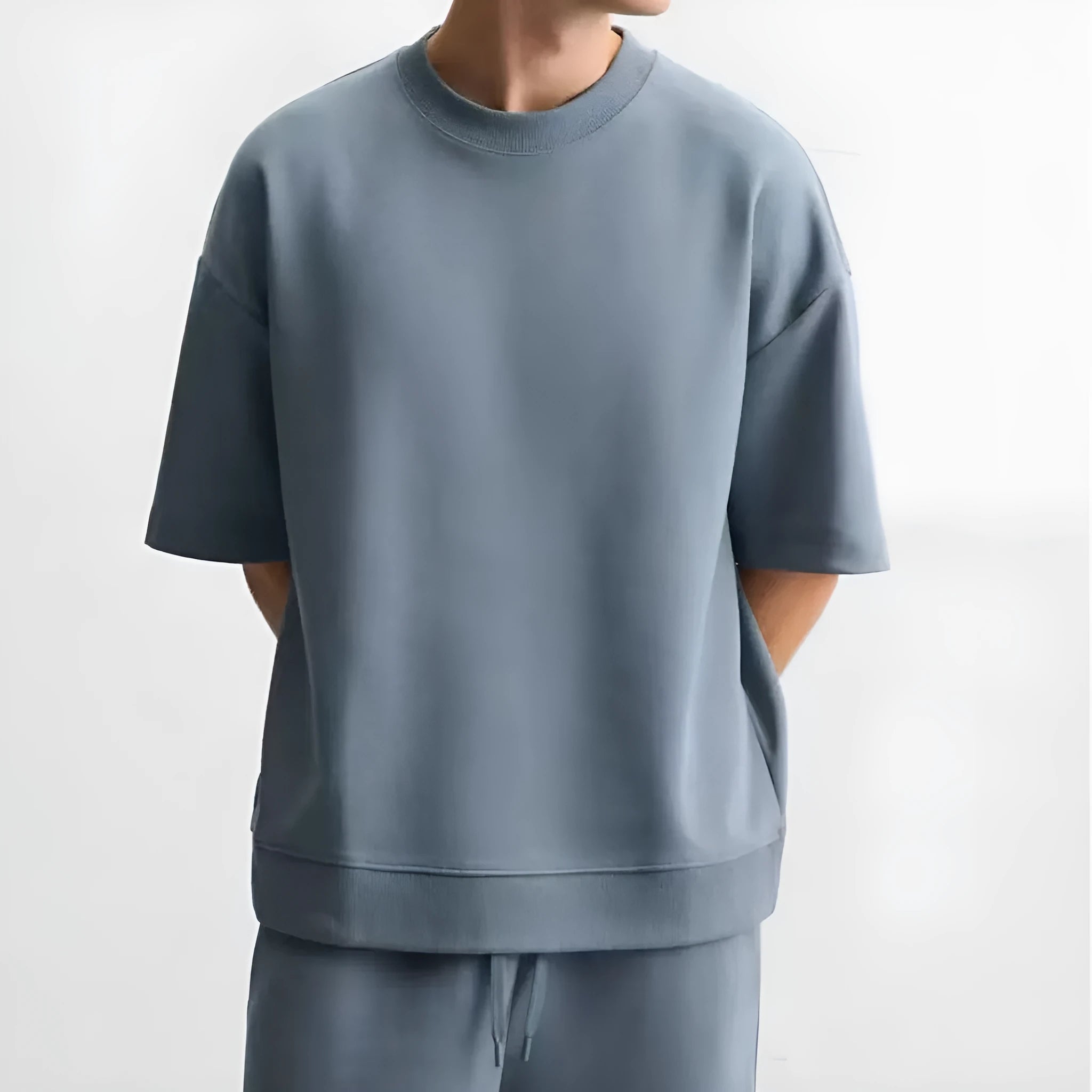 Man wearing a loose fit blue short sleeve t-shirt and matching blue shorts from a polyester two-piece set.