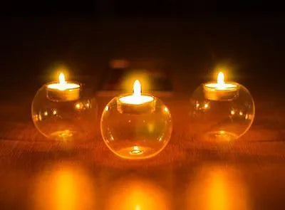 Handmade European hollow glass candle holder in round geometric design on table.