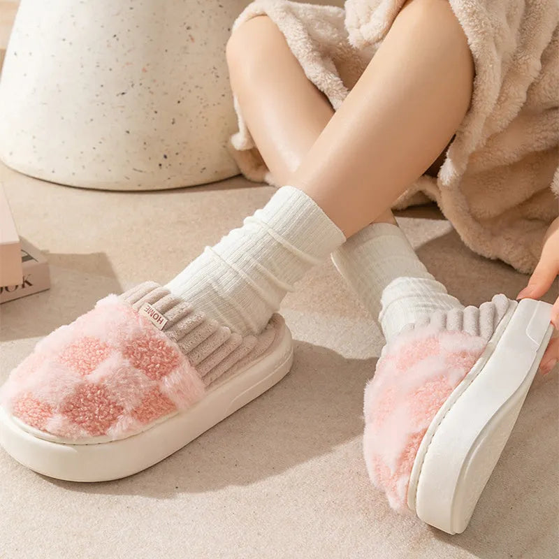 Women's plaid patterned plush slippers with non-slip sole in multiple colours on a wooden floor.