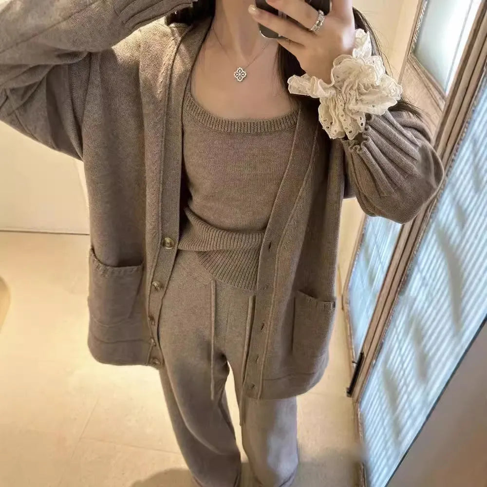 Women's light brown knit cardigan three-piece set with suspender casual pants on a hanger.