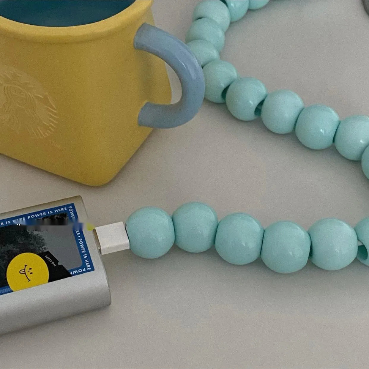 Mint green USB data cable with straight head connector on a white background