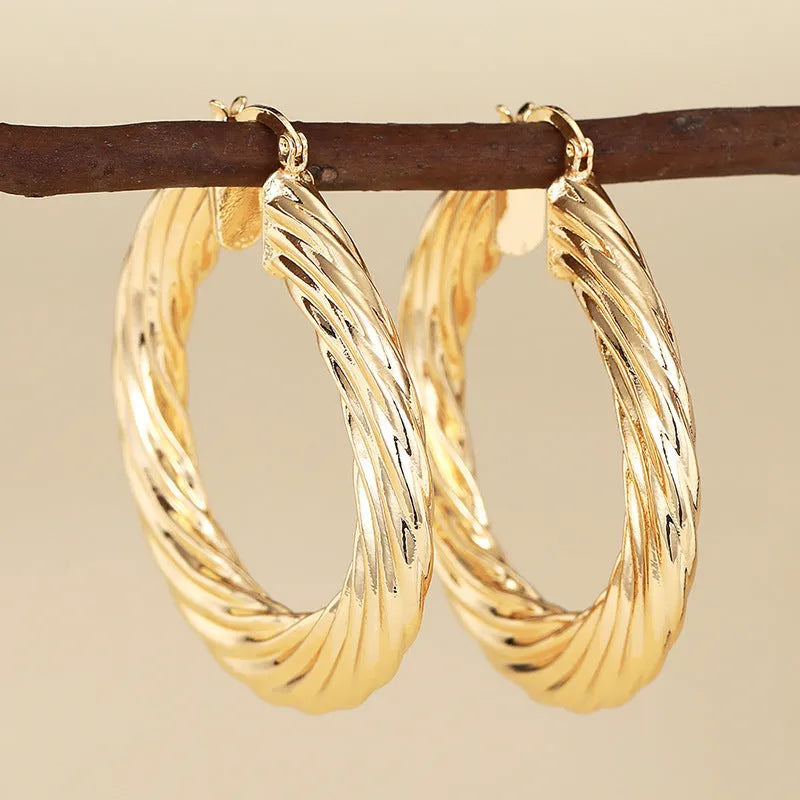 Women's geometric ring design copper clip-on earrings in electroplated colours on a white background.