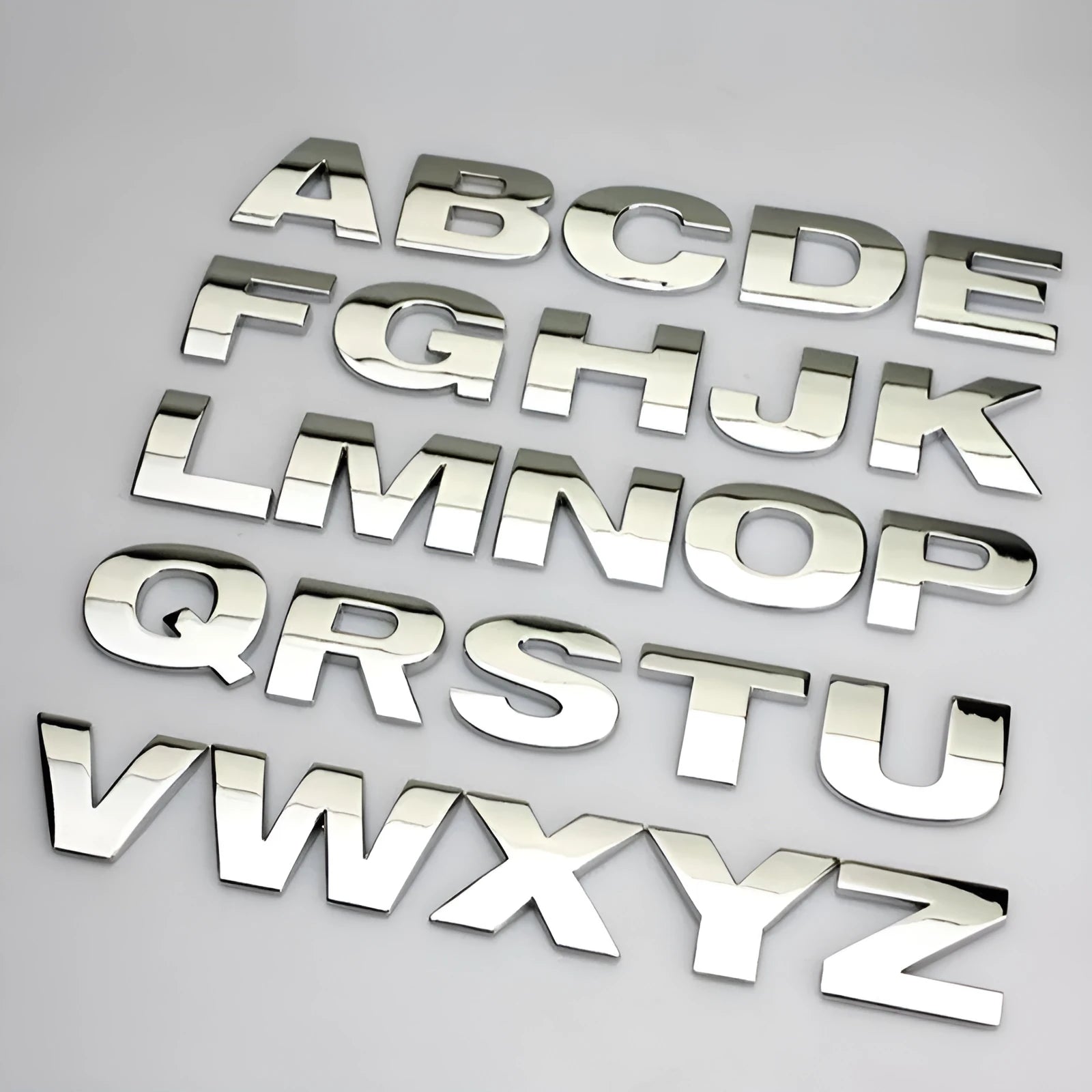 Close-up of a single 3D metal car letter sticker in zinc alloy on a vehicle bumper.