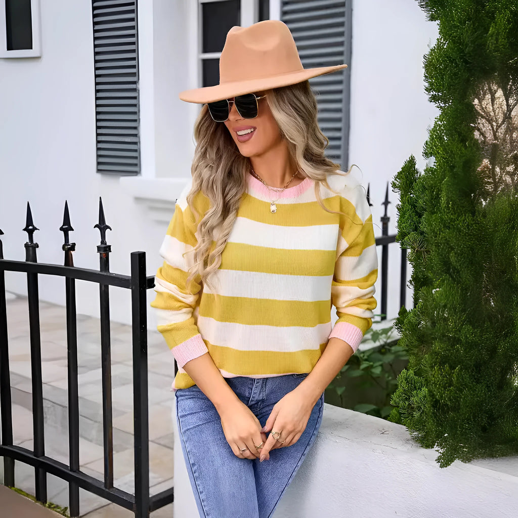 Women's loose fit acrylic sweater in blue with stripes, showing round neck and long sleeves.