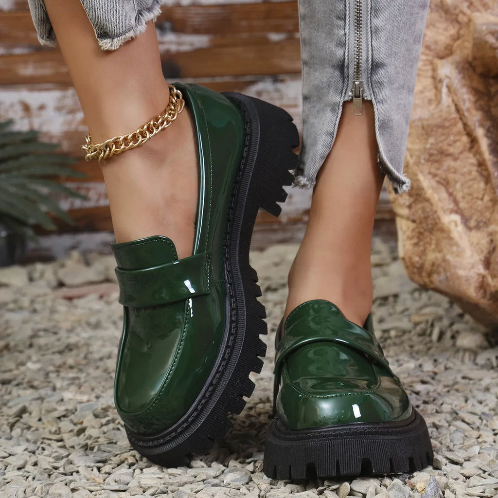 Plus size black slip-on loafers with chunky platform heel on a solid colour background