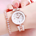Ladies quartz watch with white round dial, steel strap, and rose gold sheen on a plain background