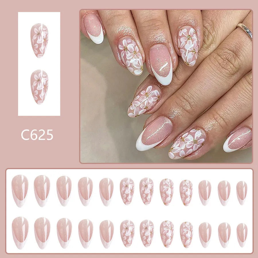 Short almond-shaped false nails with French style tips and glittering pink powder flowers on a white background.