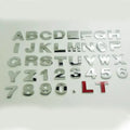 Close-up of a single 3D metal car letter sticker in zinc alloy on a vehicle bumper.