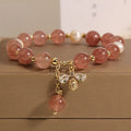 Women's bracelet with strawberry quartz beads, freshwater pearls, and a bee charm.