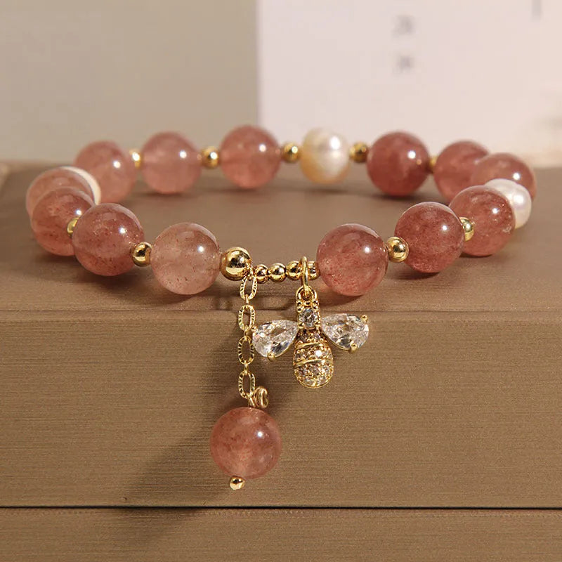 Women's bracelet with strawberry quartz beads, freshwater pearls, and a bee charm.
