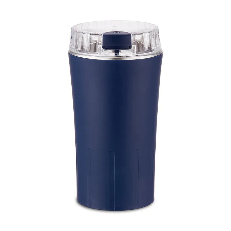 Compact blue mini flour mill and spice grinder made from stainless steel on a kitchen worktop.