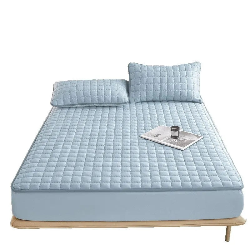 Blue washed cotton waterproof fitted sheet with elasticated edges on mattress.