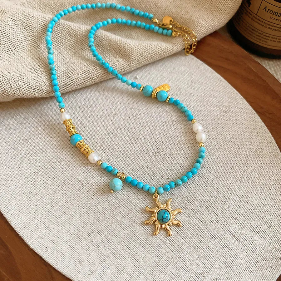 Freshwater pearl necklace with stone sun pendant on adjustable clavicle chain in blue and golden pink colours