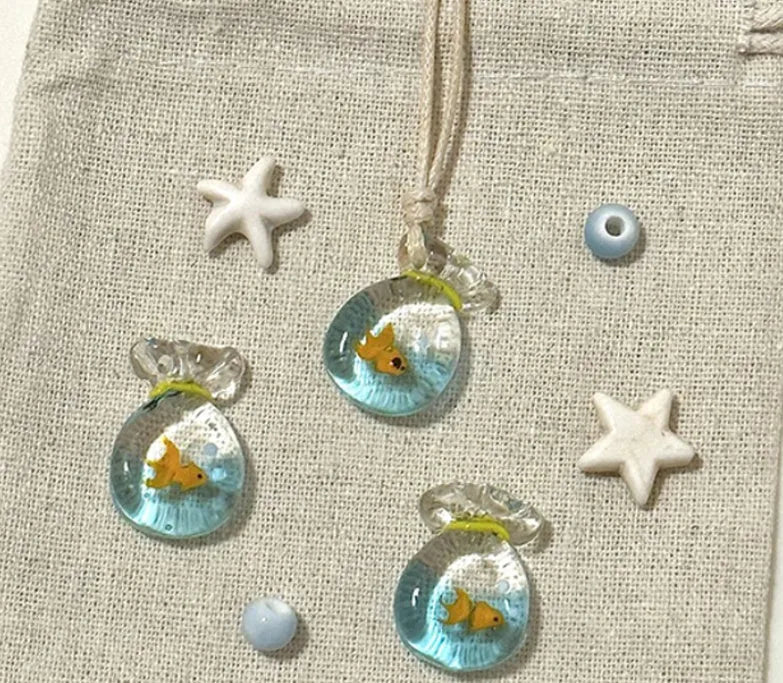 Women's necklace with coloured glaze joker pendant on a beige cotton and linen clavicle chain.