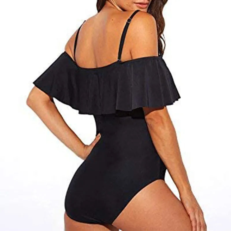 Black one-piece swimsuit with cut-out design and ruffled straps on the tube top.
