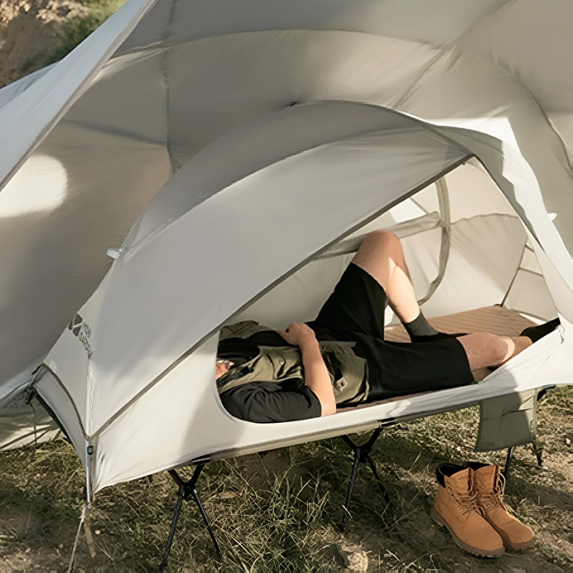Ultra-light folding white single tent with aluminium poles on grass, 2.4kg