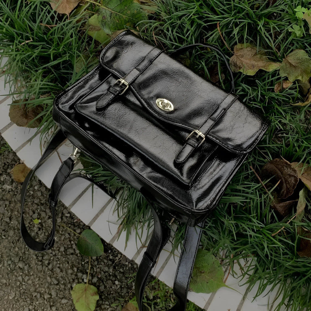 Black college style messenger bag with oil wax leather styling and adjustable strap