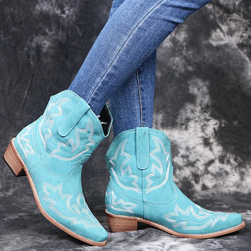 Women's blue embroidered cowboy boots with wedge heel and pointed toe on a white background.