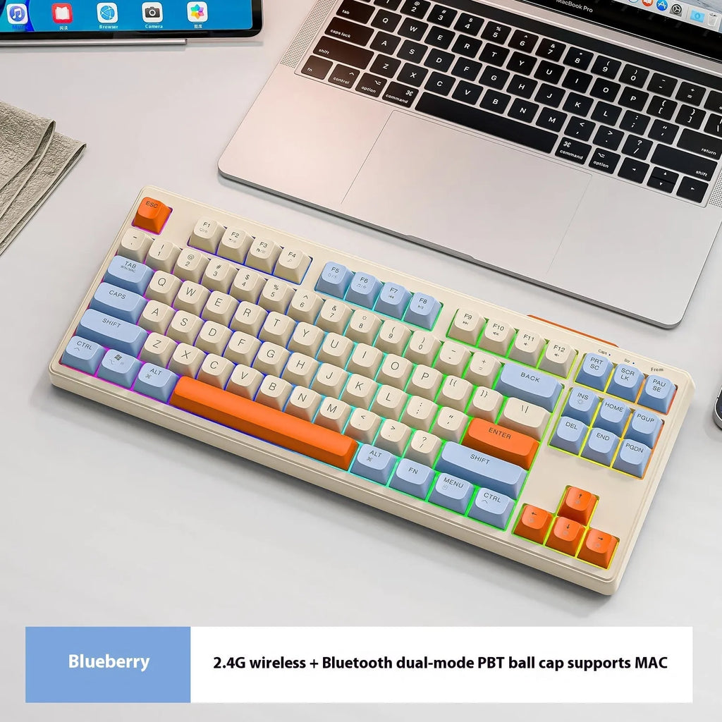Free Wolf M87 wireless dual-mode keyboard in blueberry colour on a desk with USB receiver and cable.