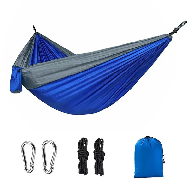 Blue parachute nylon outdoor camping hammock hung between two trees, showing its full 270 cm length.