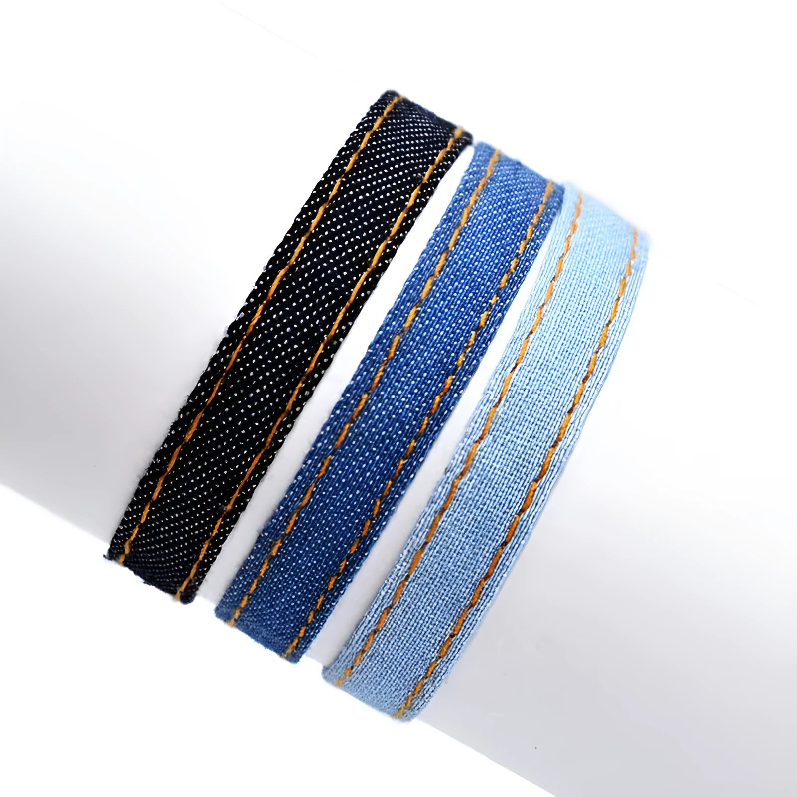 Handmade denim fabric bracelet carrying strap in national style on wrist, showing charm attachment point.
