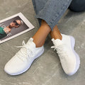 Women's low-top running shoes in Flyknit mesh, shown in creamy white colour with flat rubber sole.
