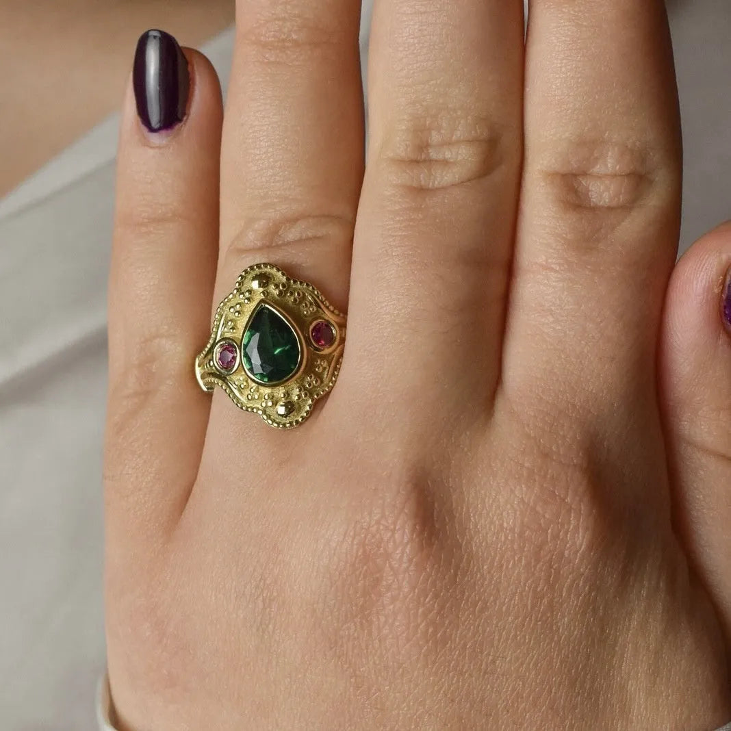 Women's geometric fashion ring in golden lvzuan colour on a grey background.