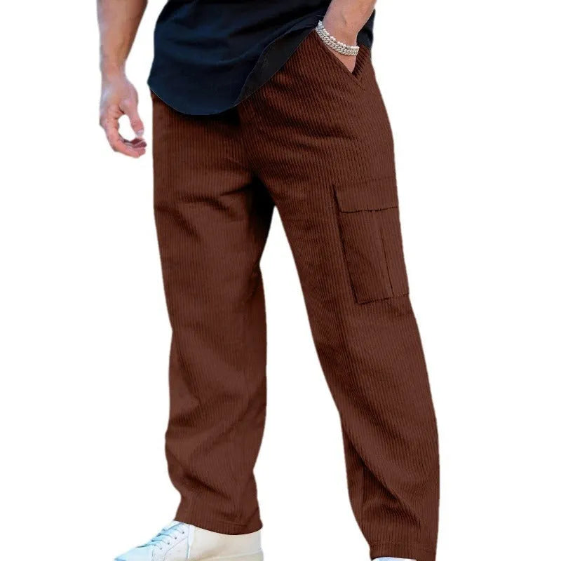Man wearing loose-fitting navy blue corduroy cargo trousers with a straight leg and drawstring waist.