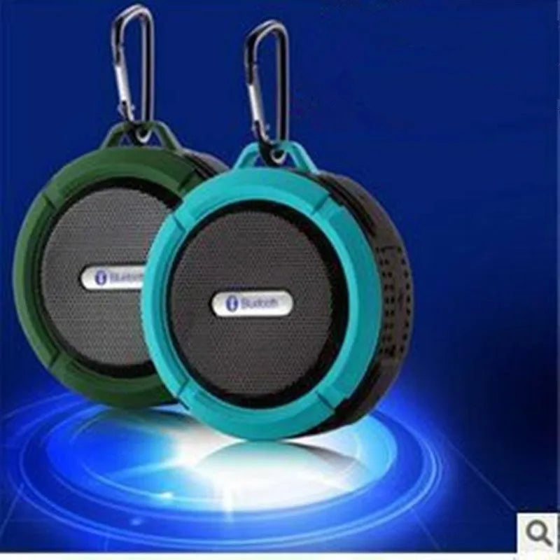 Portable waterproof Bluetooth speaker in blue with a mountaineering buckle clip for bags.