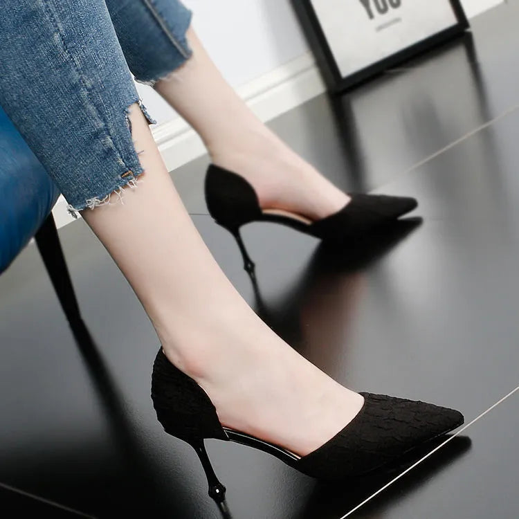 Women's black pointed stiletto heels with 6-8cm heel on wooden surface