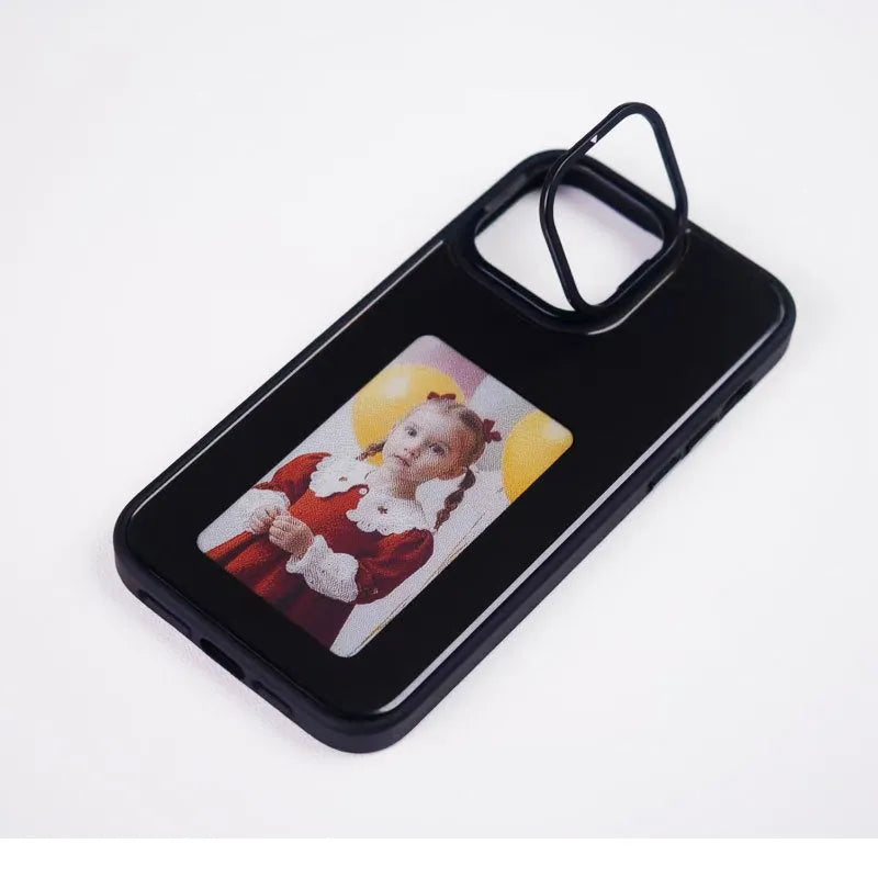 Graphite black iPhone case with a four-colour E-ink display and a fold-out standing bracket.