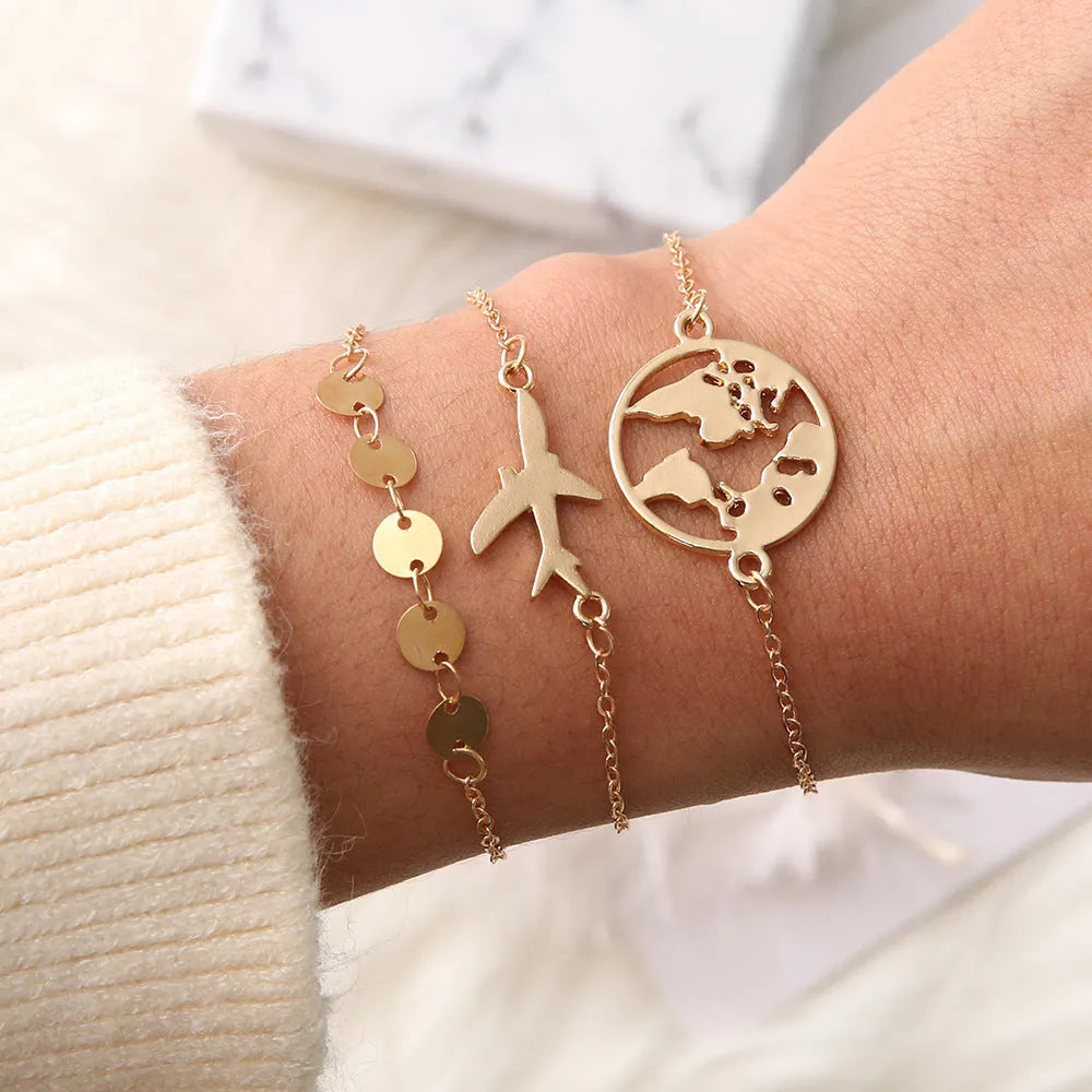 Three bohemian-style bracelets with heart-shaped aircraft map charms in electroplated alloy